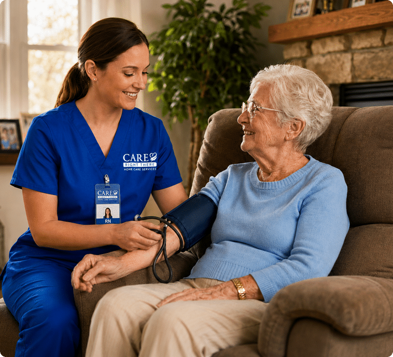 Nurse in blue scrubs measures an elderly woman's blood pressure at home.